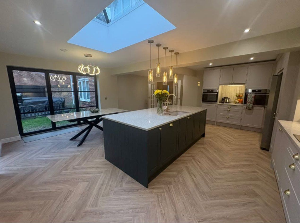 Open-plan kitchen-diner with island, roof lantern and herringbone floor