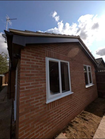 Single-storey red-brick extension with white windows and a hipped roof in Spalding
